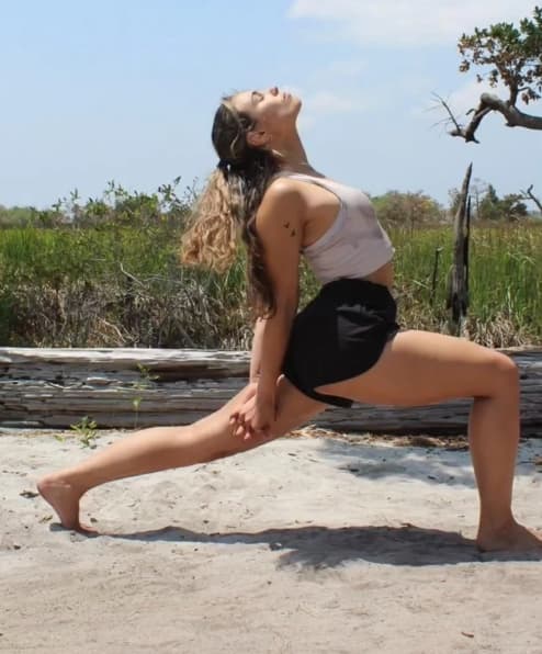 Person doing a yoga pose in a forest.